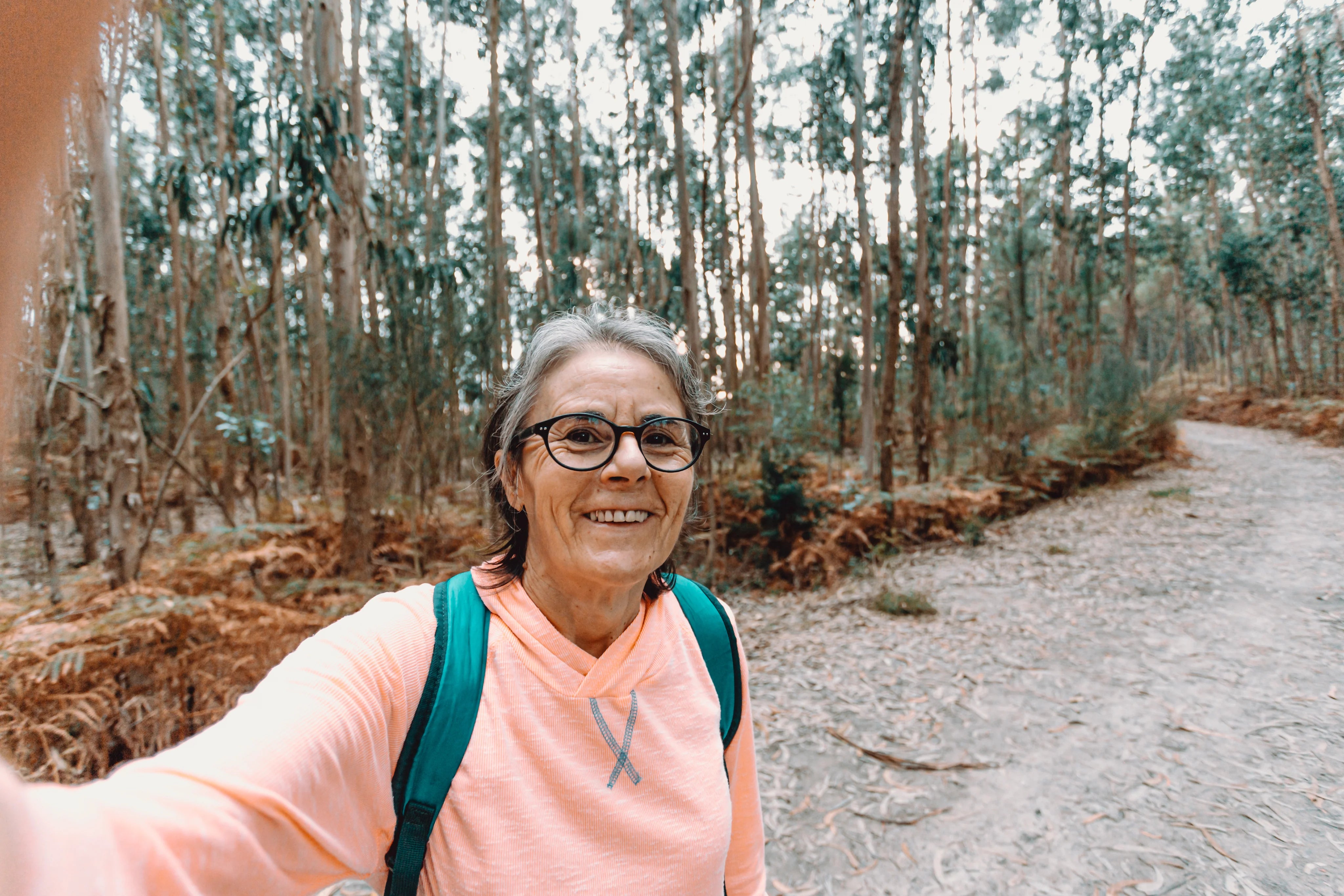 files/woman-smiles-and-takes-a-selfie-while-out-on-a-hike.webp